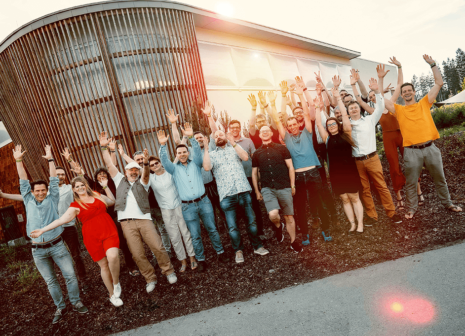 dainox team cheering in front of big modern building